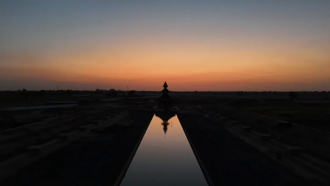 From above at dusk: the long pool and the temple, the flat land beyond