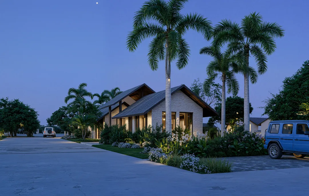 The same street at blue hour, the homes lit from within